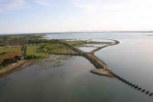 Aerial view towards the Southern embankment of the derelict railway bridge showing the 1867 railway alignment and the present day outer walls of the Oyster beds